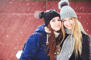 komik ve mutlu iki güzel kız arkadaşım kış aylarında kar ve kış kıyafetleri çok yürümek. sarışın ve esmer duygular.