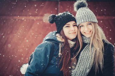 komik ve mutlu iki güzel kız arkadaşım kış aylarında kar ve kış kıyafetleri çok yürümek. sarışın ve esmer duygular.