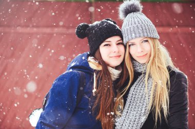 komik ve mutlu iki güzel kız arkadaşım kış aylarında kar ve kış kıyafetleri çok yürümek. sarışın ve esmer duygular.