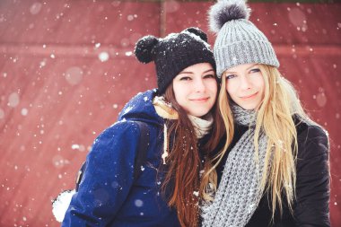 komik ve mutlu iki güzel kız arkadaşım kış aylarında kar ve kış kıyafetleri çok yürümek. sarışın ve esmer duygular.