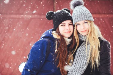 komik ve mutlu iki güzel kız arkadaşım kış aylarında kar ve kış kıyafetleri çok yürümek. sarışın ve esmer duygular.