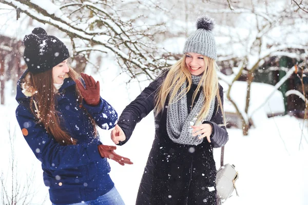 komik ve mutlu iki güzel kız arkadaşım karda kışın çok kar ve kış giysi oynamak. sarışın ve esmer duygular.