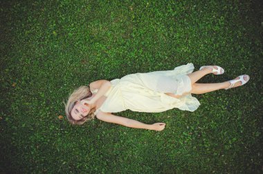 Güzel ve genç birbayan çim üzerinde yalan. Taze doğal yaz konsepti. Yukarıdan görüntüleyin. -görüntü