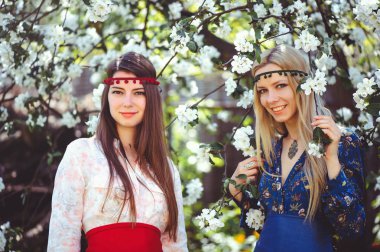 Çiçekli bahçesinde bahar zaman gülümseyen genç güzel kadın portresi. Badem çiçek çiçek açmış. Kız giyinip şık, takı başında. -görüntü