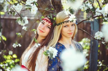 Çiçekli bahçesinde bahar zaman gülümseyen genç güzel kadın portresi. Badem çiçek çiçek açmış. Kız giyinip şık, takı başında. -görüntü