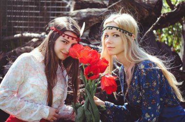 Lale ile bahar zaman gülümseyen genç güzel kadın portresi. Kırmızı lale çiçek çiçekler. Kız giyinip şık, takı başında. -görüntü