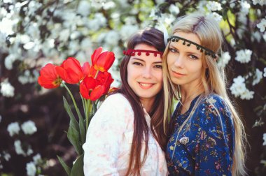 Çiçekli bahçesinde bahar zaman gülümseyen genç güzel kadın portresi. Badem çiçek çiçek açmış. Kız giyinip şık, takı başında. -görüntü