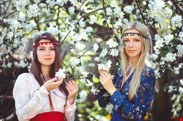 Çiçekli bahçesinde bahar zaman gülümseyen genç güzel kadın portresi. Badem çiçek çiçek açmış. Kız giyinip şık, takı başında. -görüntü