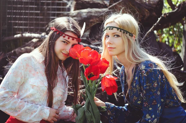 Lale ile bahar zaman gülümseyen genç güzel kadın portresi. Kırmızı lale çiçek çiçekler. Kız giyinip şık, takı başında. -görüntü