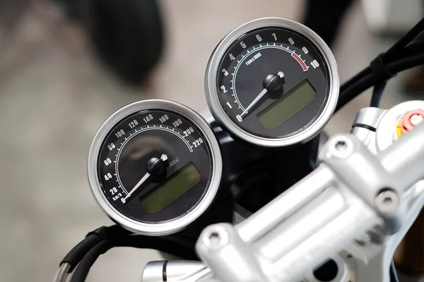 Close-up of a motorcycle speedometer with a reflection from the sensor and chrome upper handle after washing and wax. View from above