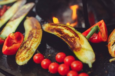 Şef ızgarada sebze pişirir. Altın, sulu ve iştah açıcı ızgara sebzeler, lezzetli gıda grubu planı