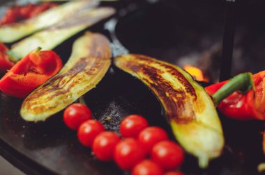 Şef ızgarada sebze pişirir. Altın, sulu ve iştah açıcı ızgara sebzeler, lezzetli gıda grubu planı