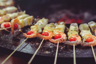 Şef ızgarada deniz ürünleri pişirir. Altın, sulu ve ağız sulandıran deniz tarağı, ızgara balık ve çırpılmış yumurta, lezzetli gıda grubu planı