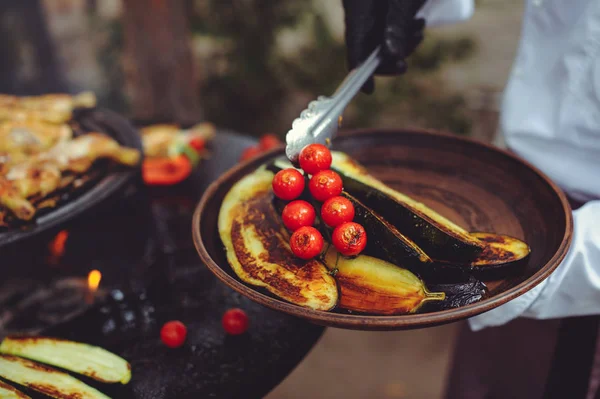 The chef cooks vegetables on the grill. Golden, juicy and appetizing grilled vegetables, delicious food group plan