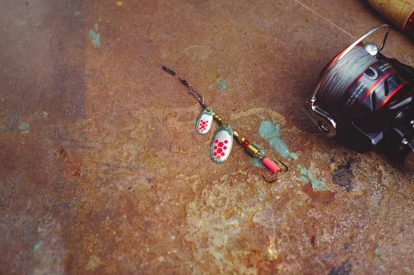 Aparejos de pesca: pesca giratoria, anzuelos y señuelos sobre un fondo de óxido oscuro. Vista desde arriba. Foto para tipografía, póster, pancarta, postal. Todo para la pesca — Foto de Stock