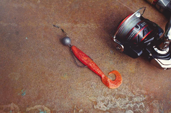 Cañas de pescar giratorias, anzuelos de pesca, cebos de silicona sobre un fondo de madera con lugar para texto, foto para tipografía, póster, pancarta, postal. Todo para la pesca — Foto de Stock