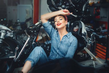 Güzel bir kız atölyede motosiklet tamir ediyor, poster tarzı, servis ve satış..