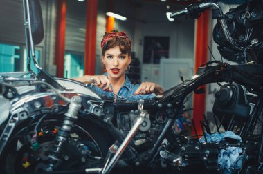 Güzel bir kız atölyede motosiklet tamir ediyor, poster tarzı, servis ve satış..