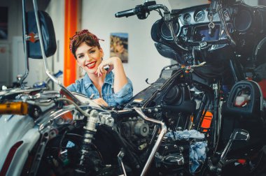 Güzel bir kız atölyede motosiklet tamir ediyor, poster stili, servis ve satış..