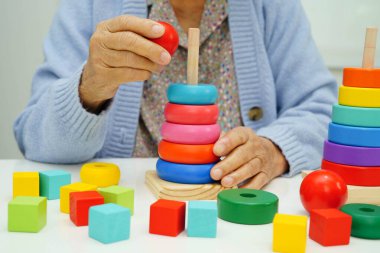 Asyalı yaşlı bir kadın, geliştirme oyunu oynuyor..