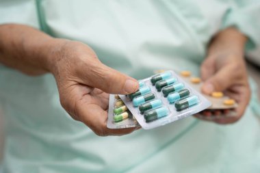 Asyalı yaşlı kadın elinde hap tutuyor, güçlü sağlıklı tıbbi konsept..