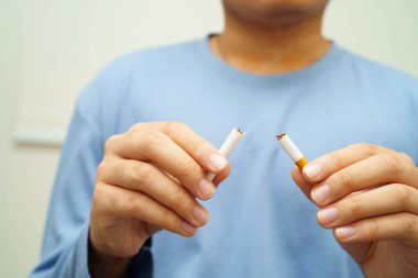 Sigarayı bırak, Asyalı adam kırıyor sigarayı elinde yok et.