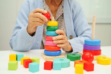 Asyalı yaşlı bir kadın, geliştirme oyunu oynuyor..