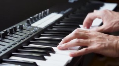 Stüdyoda MIDI klavye / MIDI denetleyici sentezleyici çalan müzisyen - elektronik müzik prodüksiyonu / kaydı için seçici-odaklı piyano tuşları yakın plan