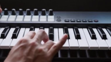 Stüdyoda MIDI klavye / MIDI denetleyici sentezleyici çalan müzisyen - elektronik müzik prodüksiyonu / kaydı için seçici-odaklı piyano tuşları yakın plan