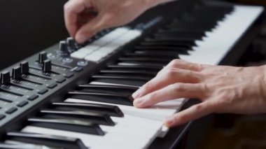 Stüdyoda MIDI klavye / MIDI denetleyici sentezleyici çalan müzisyen - elektronik müzik prodüksiyonu / kaydı için seçici-odaklı piyano tuşları yakın plan
