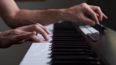 Stüdyoda MIDI klavye / MIDI denetleyici sentezleyici çalan müzisyen - elektronik müzik prodüksiyonu / kaydı için seçici-odaklı piyano tuşları yakın plan