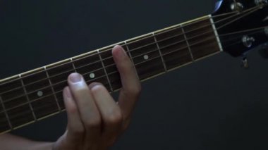 Gitarist akustik gitar oynarken stüdyo seçici odak yakın yukarı klavye ve el rock pop akorları oynuyor