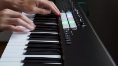 Stüdyoda MIDI klavye / MIDI denetleyici sentezleyici çalan müzisyen - elektronik müzik prodüksiyonu / kaydı için seçici-odaklı piyano tuşları yakın plan