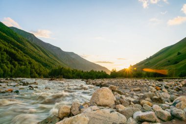 Gürcistan 'ın Svaneti bölgesindeki Mestia köyü yakınlarında gün batımında dağlar ve nehirle kaplı Svaneti manzarası..