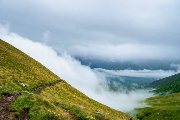 Kazbegi, Georgia - Mountain landscape of Mount Kazbegi landscape with dramatic clouds up in the trekking and hiking route.