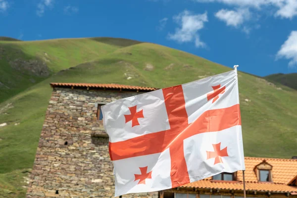 Georgian flag waving against  blue sky - flag of Georgia, the country known until 1995 as the Republic of Georgia