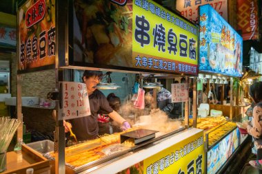 Taipei, Tayvan - Mart 2019: Shilin gece pazarında Kokuşmuş Tofu Sokağı yiyecek satıcısı. Shilin gece pazarı genellikle Taipei 'deki en büyük ve en ünlü gece pazarı olarak kabul edilir..