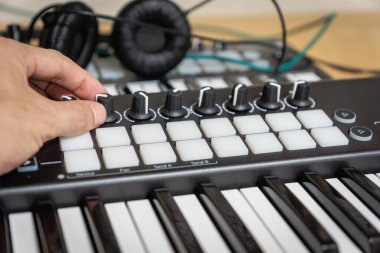 Stüdyoda MIDI klavye / MIDI denetleyici sentezleyici çalan müzisyen - elektronik müzik prodüksiyonu / kaydı için seçici-odaklı piyano tuşları yakın plan