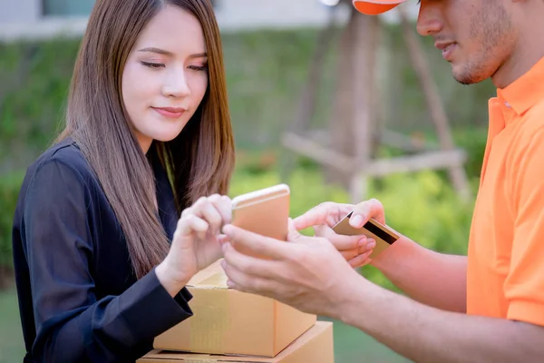 Delivery man is asking woman to sign mobile for the delivery
