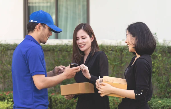 Delivery man is asking woman to sign mobile for the delivery