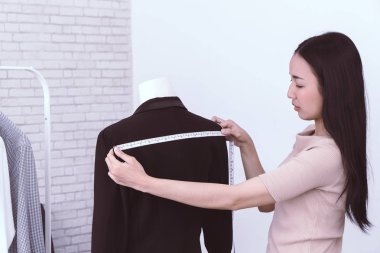 Moda Tasarımcısı el, ölçü bandıyla omuz ölçüyor.