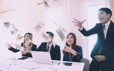 İş ekibi ve partneri para saçarak kutlama yapıyor. 