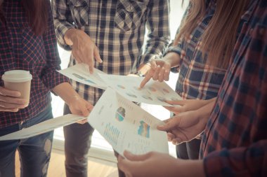 İş toplantısı için veri tablosunu gösteren eller