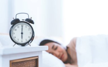 Çalar saat hala yatakta uyuyan kadın ile altı saat için sayma