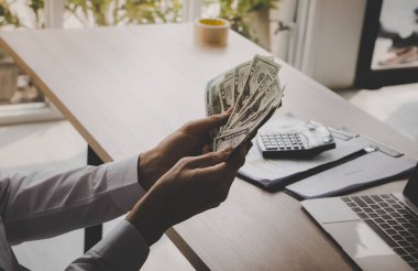 İşadamı ofiste dolar sayıyor.