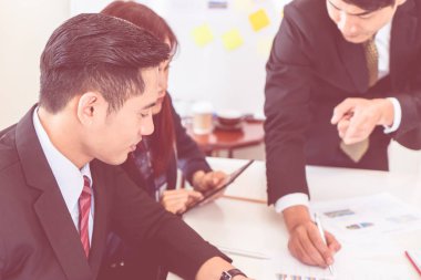 İş adamı toplantıda metal kalem kullanarak veri sayfası olarak işaretleme