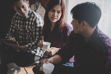Günlük iş kurma ekibi bir kahve kafede tartışıyor.
