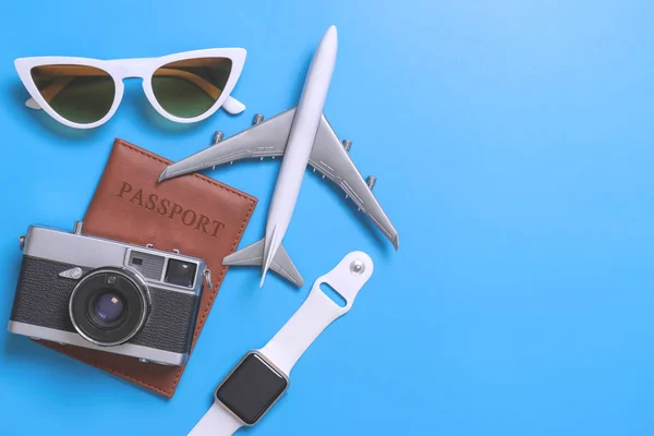 Travel blogger accessories on blue copy space