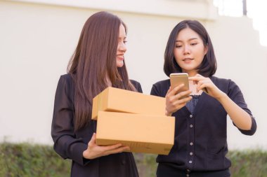 Mutlu Asyalı kadın online alışveriş yapmak için akıllı telefon kullanıyor.