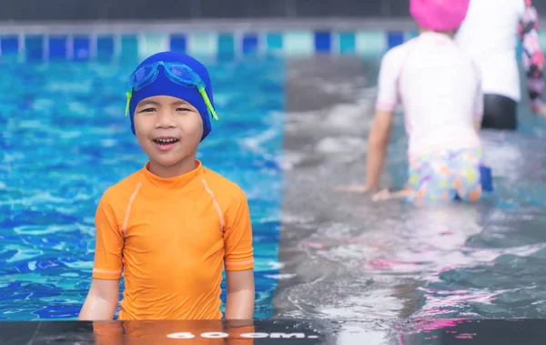 Wet suit swim Asian boy is standing on pool side